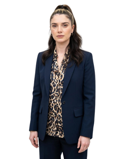Woman wearing a navy blazer over a leopard print top on a white background
