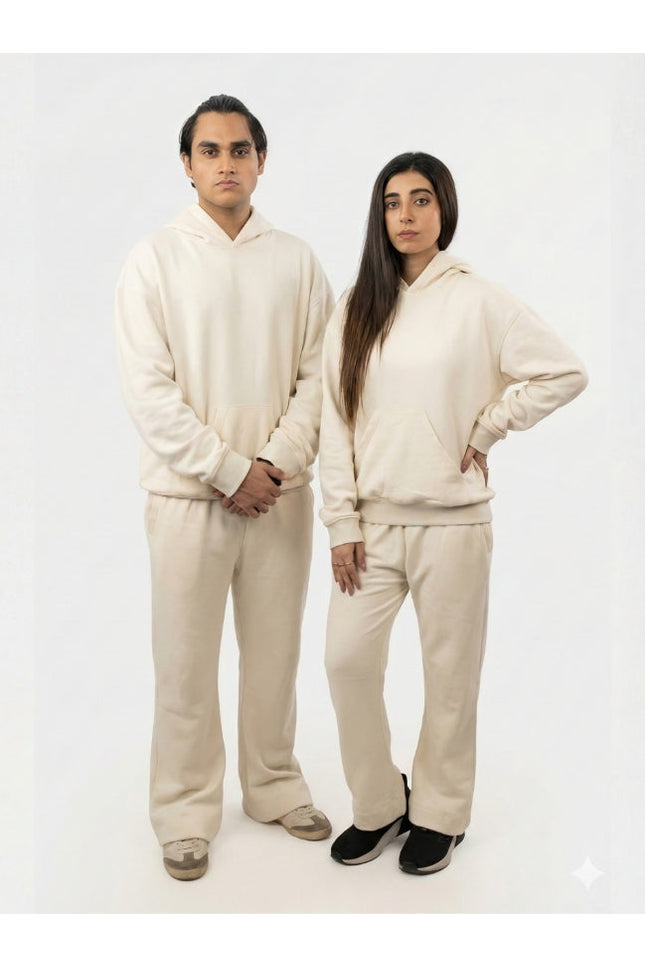 Two people wearing matching beige outfits on a white background