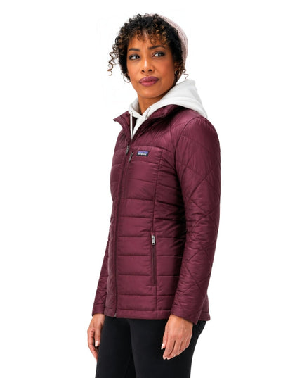 Woman wearing a maroon quilted jacket with a white hood on a white background