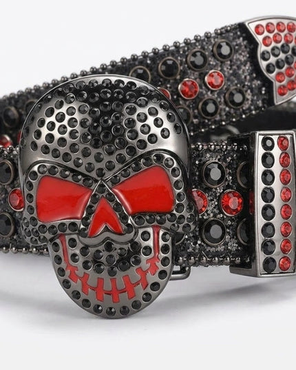 Belt buckle with skull design featuring red and black stones on a white background