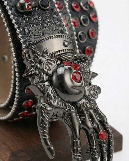 Decorative belt buckle with intricate design and red gemstones on a white background