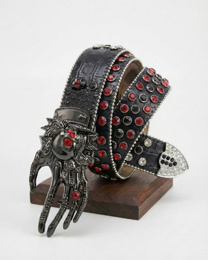 Decorative belt with red gemstones and a hand-shaped buckle on a stand against a white background