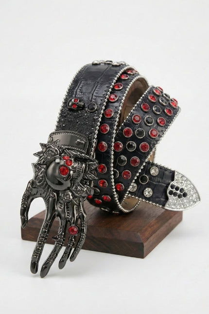 Decorative belt with red gemstones and a hand-shaped buckle on a stand against a white background