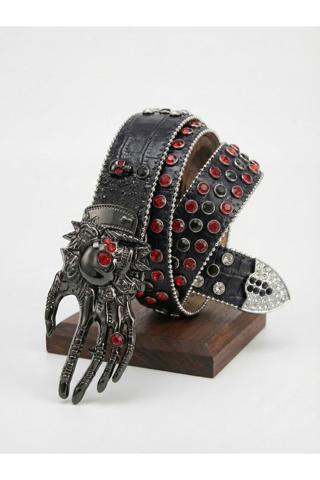 Decorative belt with red gemstones and a hand-shaped buckle on a stand against a white background