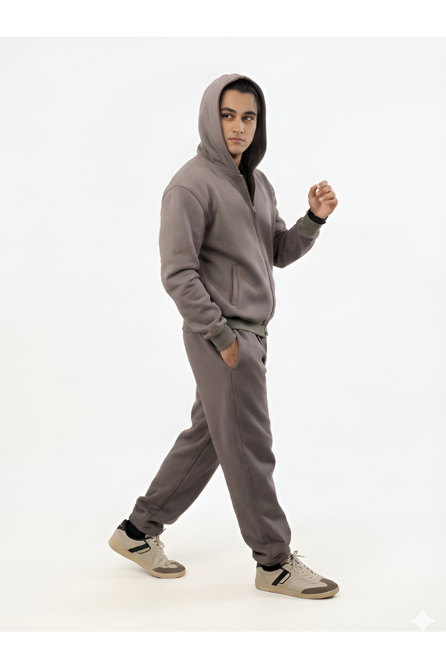 Person wearing a gray hoodie and pants on a white background