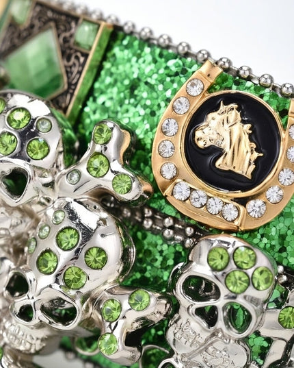 Close-up of decorative items with green gemstones and gold accents on a green glittery background.
