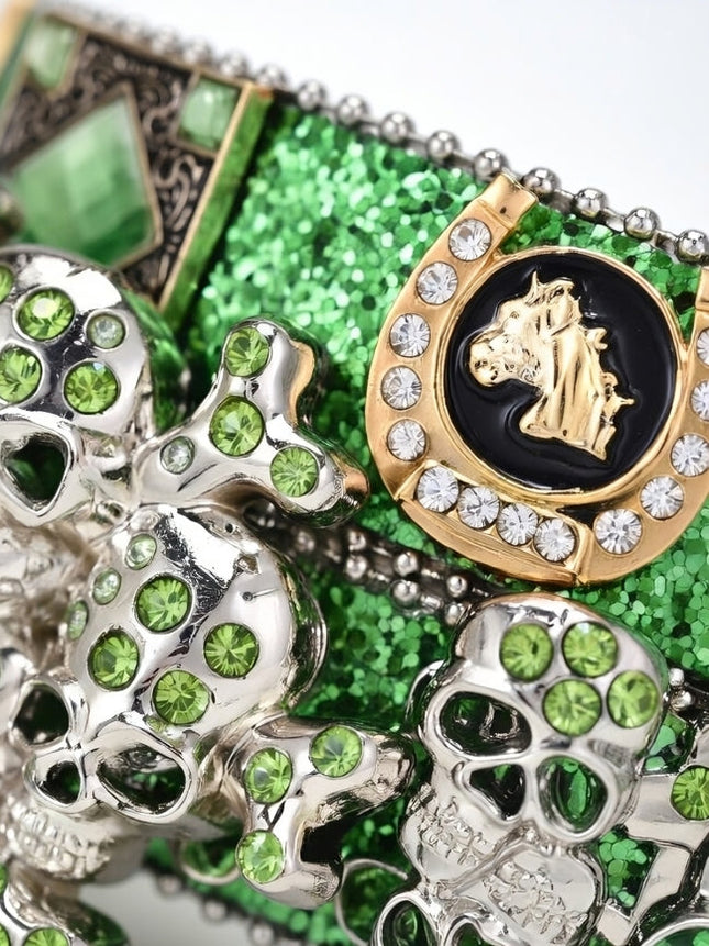 Close-up of decorative items with green gemstones and gold accents on a green glittery background.