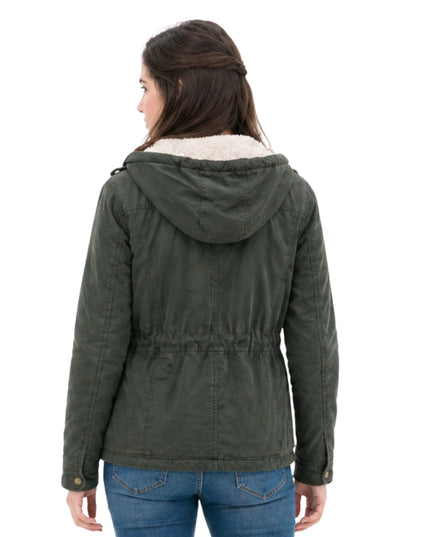 Person wearing a green hooded jacket with white lining on a white background