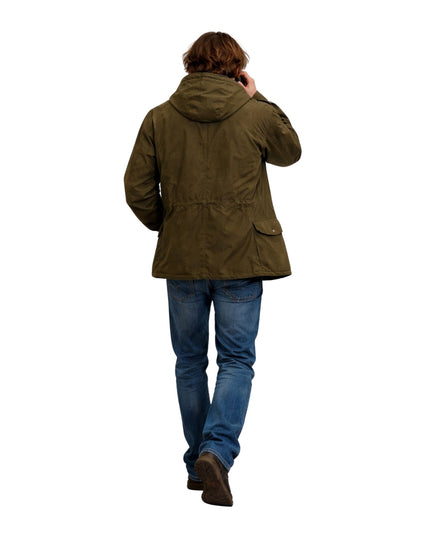 Person wearing a green jacket and blue jeans on a white background