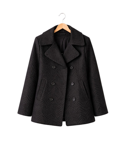 Black coat on a hanger against a white background