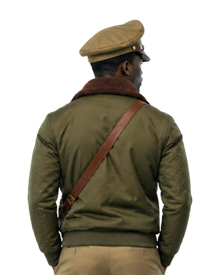 Person wearing a green jacket with a brown leather strap over a white background
