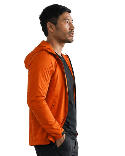 Man wearing an orange hoodie with a black shirt underneath on a white background