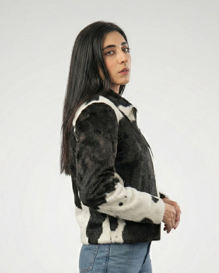 Person wearing a black and white patterned jacket on a plain background
