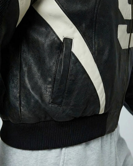 Close-up of a black leather jacket with white accents on a white background