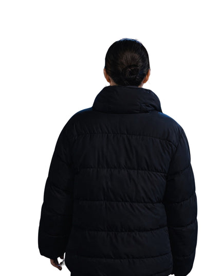 Person wearing a black puffer jacket on a white background