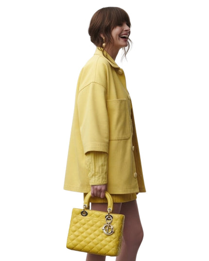 Person wearing a yellow outfit with a matching handbag on a white background