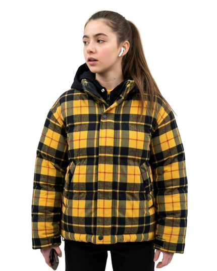 Person wearing a yellow and black plaid jacket on a white background