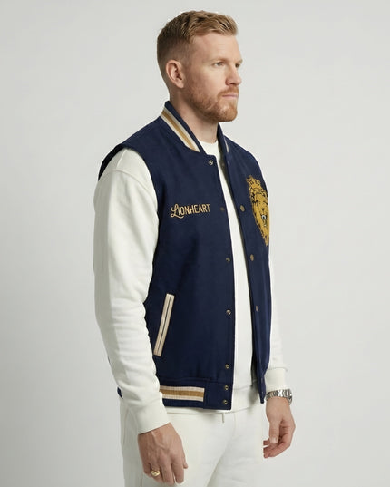 Man wearing a navy and white varsity jacket with 'Lionheart' branding on a light gray background