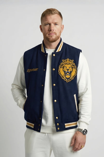 Man wearing a navy blue letterman jacket with a lion emblem on a white background