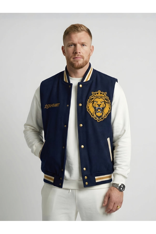 Man wearing a navy blue letterman jacket with a lion emblem on a white background
