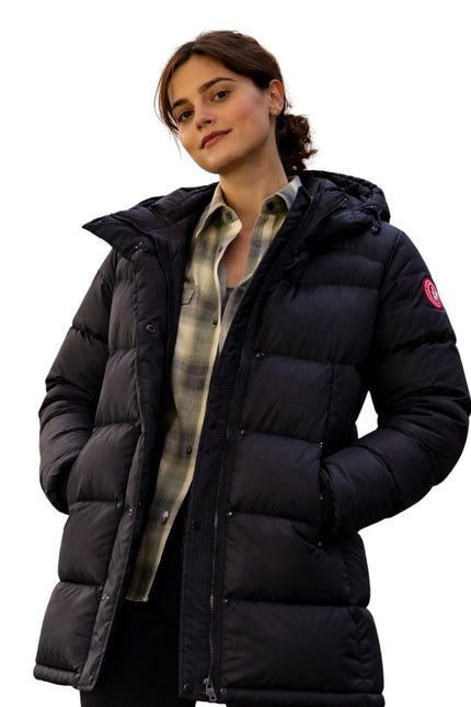 Woman wearing a black puffer jacket on a white background