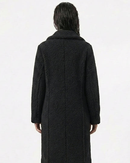 Person wearing a black coat from behind on a white background