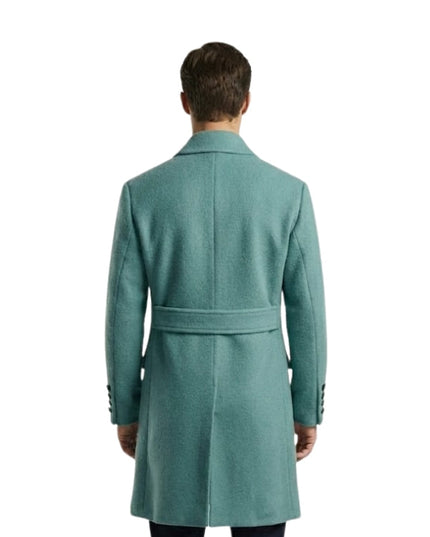 Man wearing a teal coat on a white background