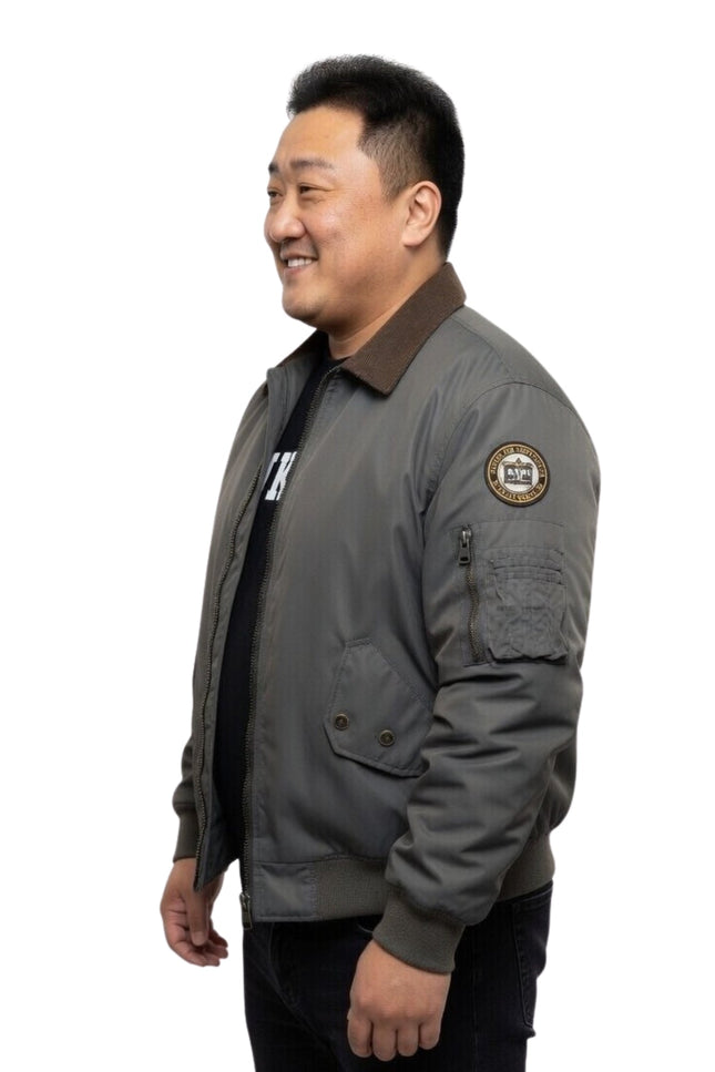 Man wearing a gray jacket with a patch on a white background