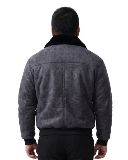 person wearing black jacket standing in front of a white background 