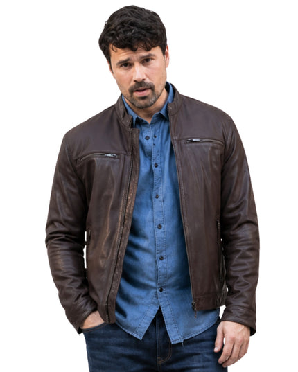 Man wearing a brown leather jacket over a blue shirt on a white background