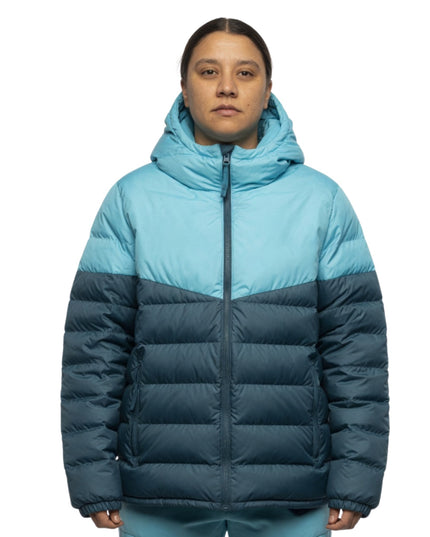 Person wearing a two-tone blue and navy puffer jacket on a white background