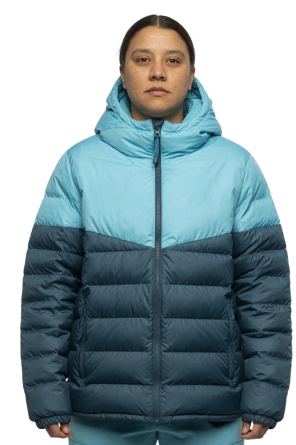 Person wearing a two-tone blue and navy puffer jacket on a white background