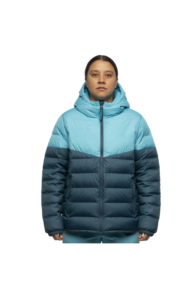 Person wearing a two-tone blue and navy puffer jacket on a white background