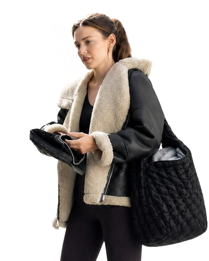 Woman holding a black textured bag and a phone on a white background
