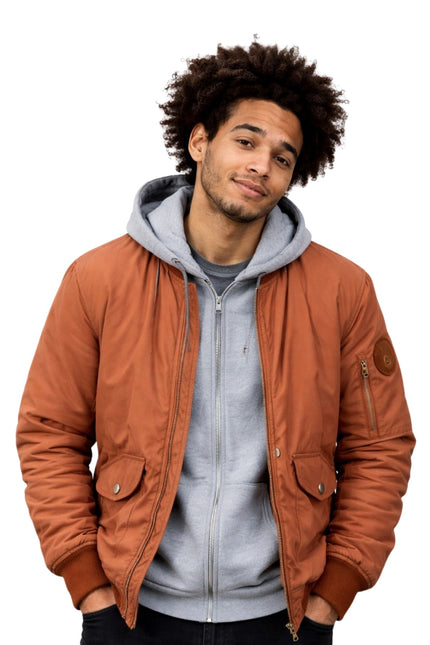 Man wearing a brown jacket over a gray hoodie on a white background