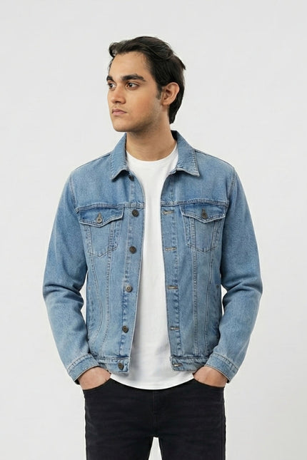 Man wearing a denim jacket over a white shirt on a light gray background