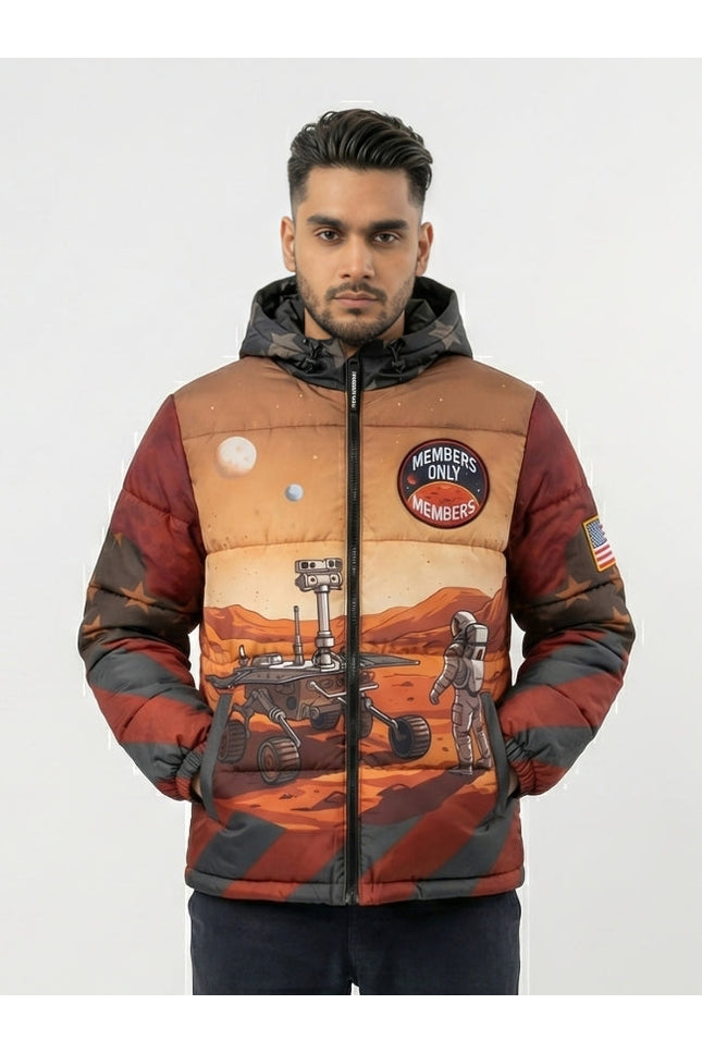 Man wearing a space-themed jacket with patches and graphics on a plain background