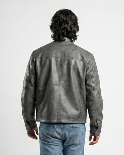 Person wearing a gray leather jacket and blue jeans on a white background