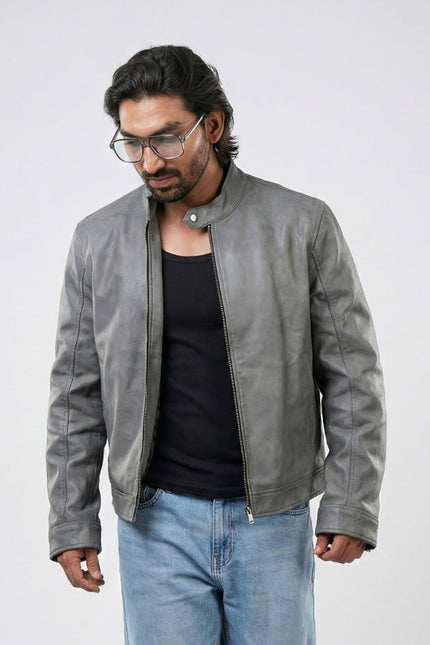 Man wearing a gray leather jacket and blue jeans on a white background