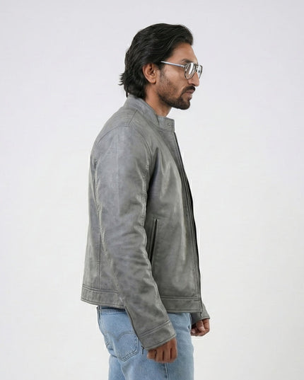 Man wearing a gray jacket and light blue jeans against a white background
