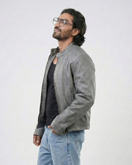 Man wearing a gray jacket and blue jeans against a white background