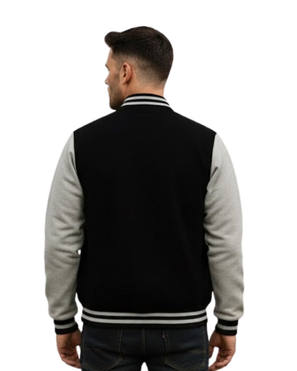 Man wearing a black and gray varsity jacket on a white background