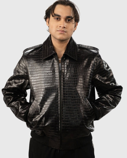 Person wearing a shiny black jacket with a textured pattern on a white background