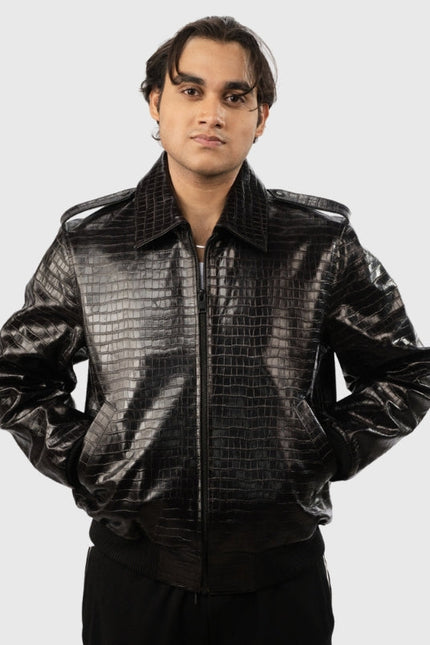 Person wearing a shiny black jacket with a textured pattern on a white background