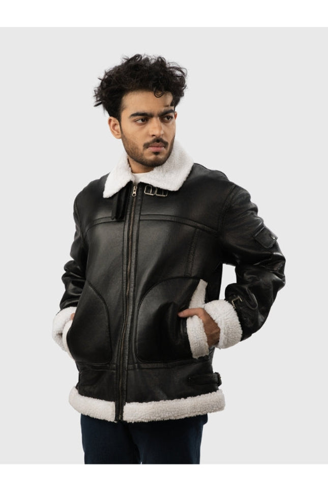 Man wearing a black leather jacket with white fur trim on a light gray background