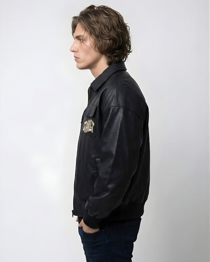 Person wearing a black leather jacket with a logo on a white background