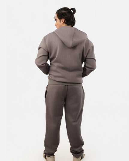 Person wearing a gray tracksuit on a white background
