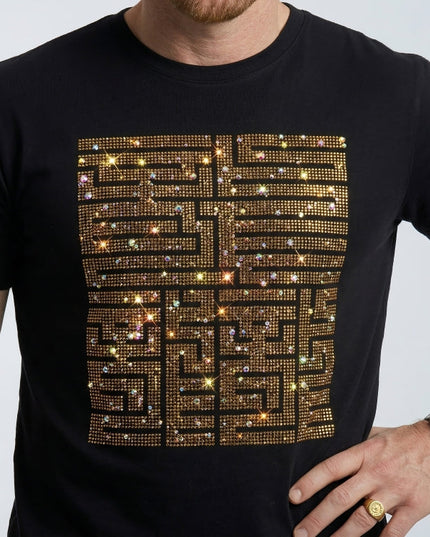 Black t-shirt with gold and silver embellishments worn by a person.