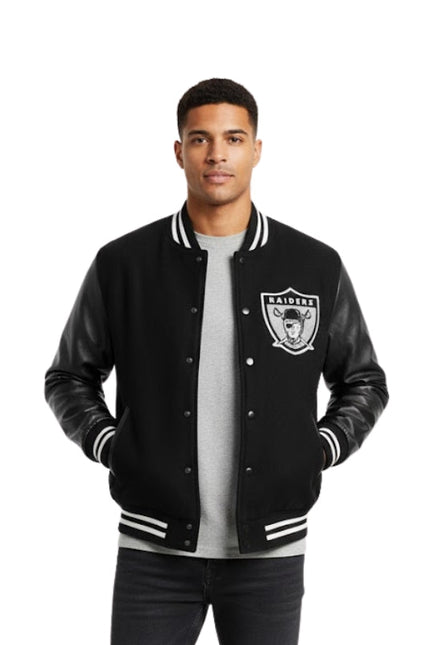 Man wearing a black varsity jacket with a logo on a white background