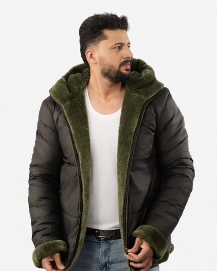 Man wearing a dark green puffer jacket with olive green hood and cuffs on a white background